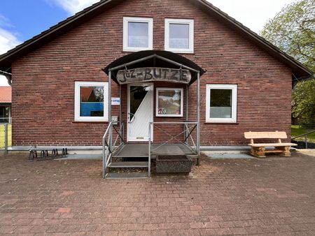 Das Jugendzentrum „Butze“ in Amelinghausen mit roter Backsteinfassade, weißer Eingangstür und kleiner Holzbank vor dem Gebäude.