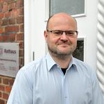 „Stephan Kaufmann, Geschäftsbereichsleiter Finanzen der Samtgemeinde Amelinghausen, steht vor dem Eingang des Rathauses und blickt freundlich in die Kamera.“