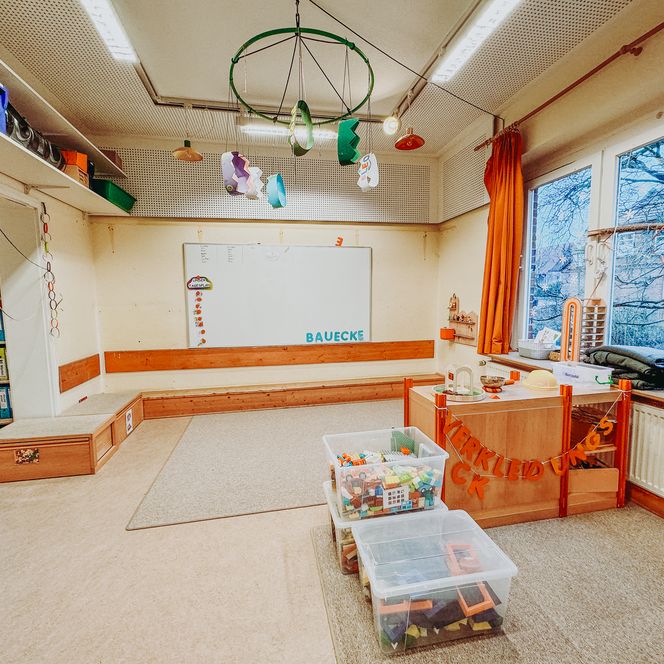 Spielecke in der Kita Betzendorf mit Bauklötzen, Verkleidungsecke, Sitzpodest und kindgerechter Einrichtung.