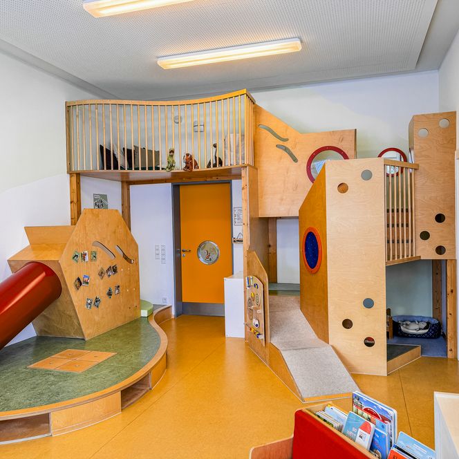 Spiel- und Kletterlandschaft in der Kinderkrippe Amelinghausen mit Rutsche, Podesten, Rampen und Holzkonstruktion.
