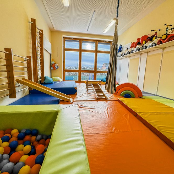 Bewegungsraum in der Kinderkrippe Amelinghausen mit Bällebad, Kletterelementen, Turnmatten und Spielsachen